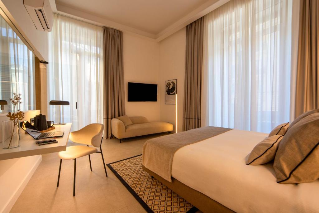 那不勒斯MAMALU - Studios and Suites的酒店客房设有一张大床和一张书桌。
