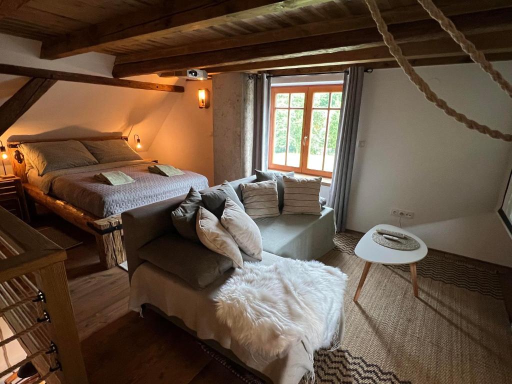 VidochovLittle Cottage No.100的一间卧室配有一张床、一张沙发和一个窗口