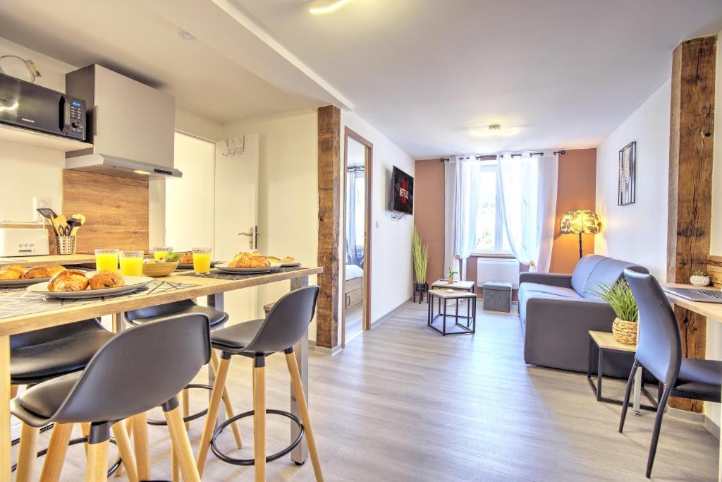 班纳萨克Le Sabot - Netflix/Wi-Fi Fibre/Terasse - 4 pers的厨房以及带桌椅的起居室。