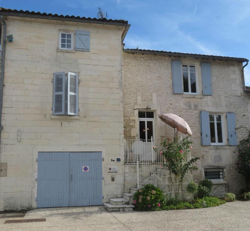 Bourg-CharenteLa Maison de Riviere的一座大型石头房子,设有蓝色车库