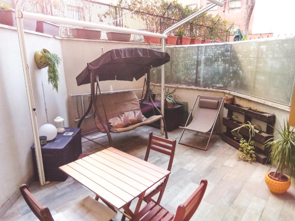 罗马Cozy flat with terrace at Trastevere train station的庭院配有桌椅和遮阳伞。