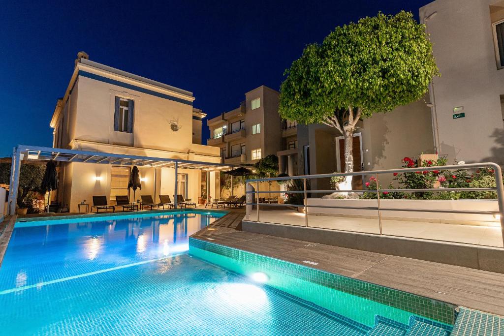 干尼亚克雷塔埃琳娜酒店的一座游泳池,在晚上在建筑物前