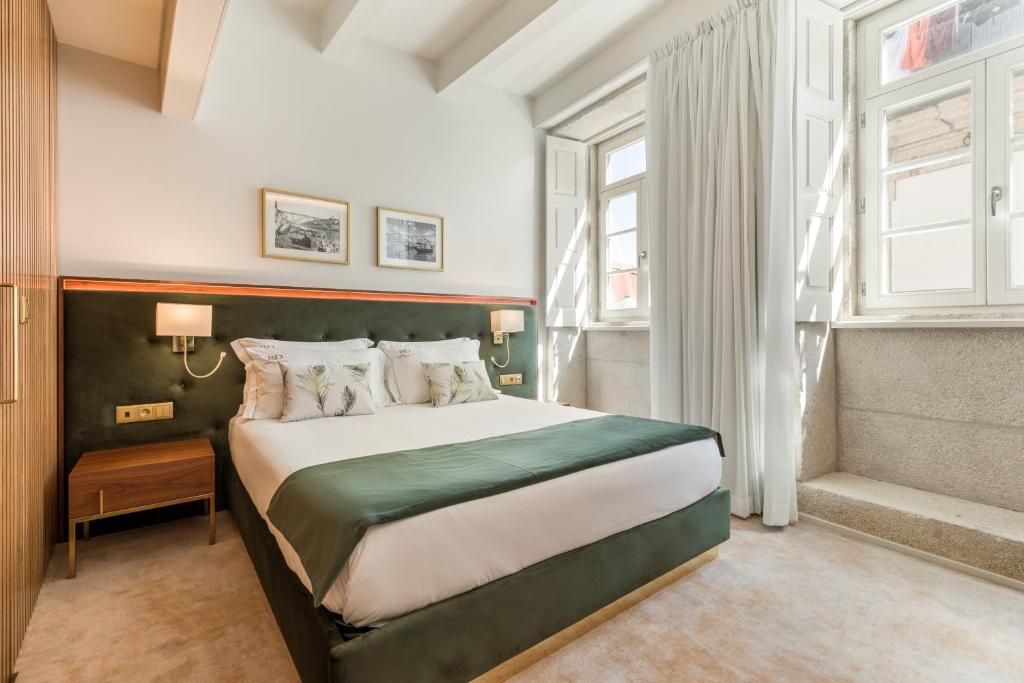 波尔图Ribeira Douro Hotel的一间卧室设有一张大床和一个窗户。