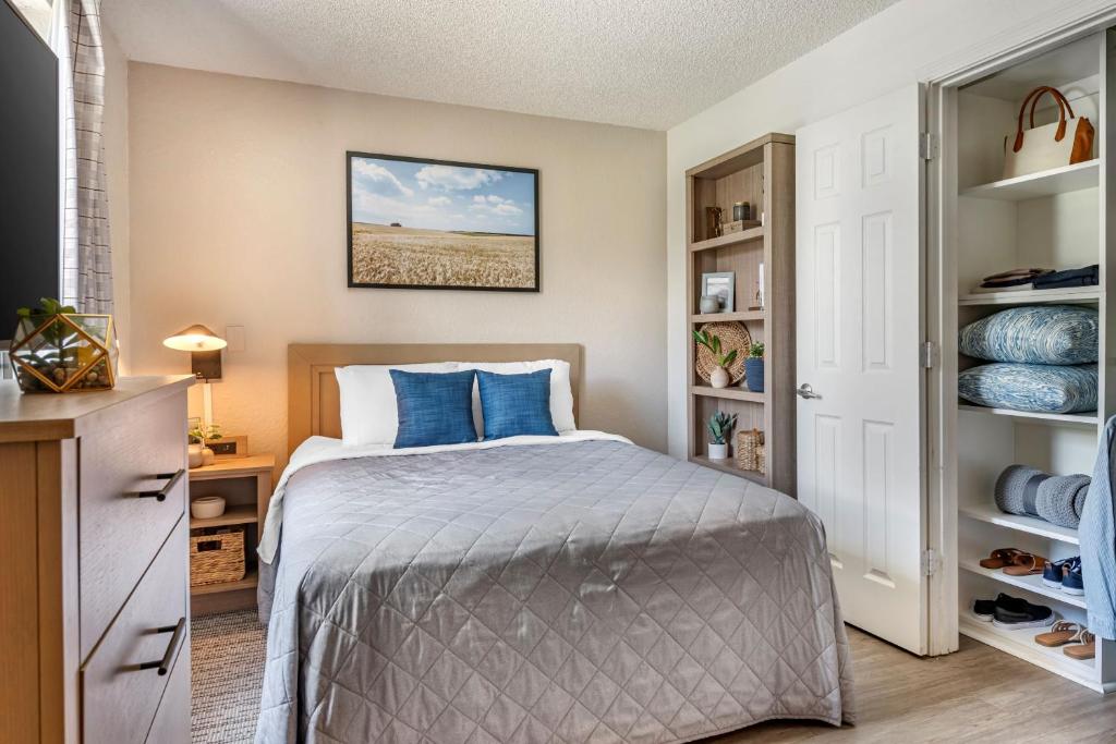奥兰多InTown Suites Extended Stay Orlando FL – Presidents Dr的一间卧室配有一张带蓝色枕头的床