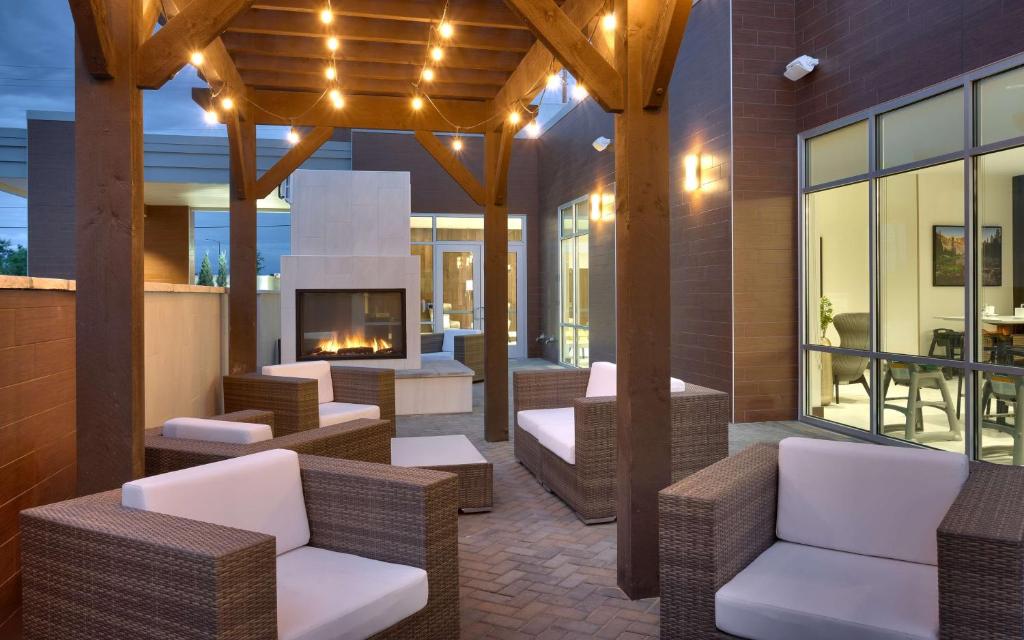 博伊西Hilton Garden Inn Boise Downtown的户外庭院设有藤椅和壁炉