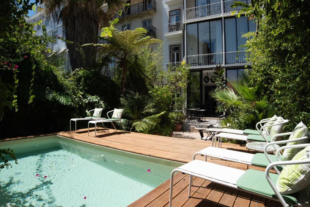 里斯本巴朗住宿加早餐旅馆的一个带椅子的甲板和一座带大楼的游泳池