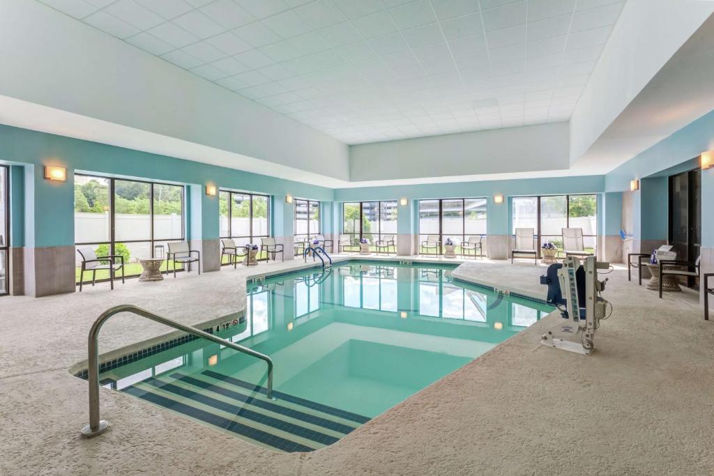 沃尔瑟姆波士顿沃尔瑟姆希尔顿花园旅馆的大型客房的游泳池,设有蓝色的墙壁和窗户