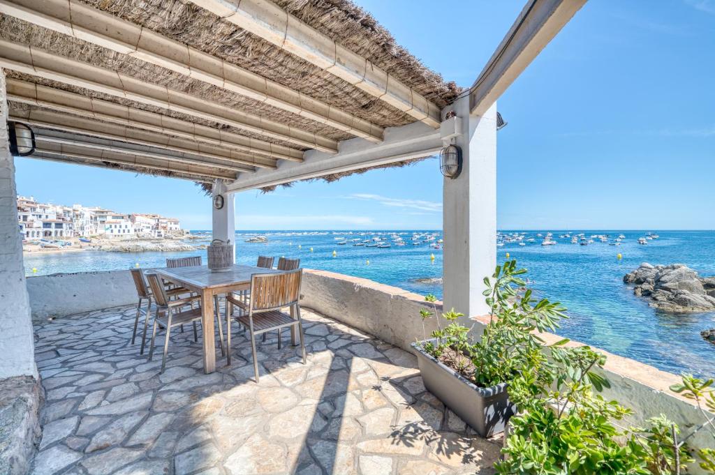卡莱利亚德帕拉弗鲁赫尔Exclusive Beach House Calella de Palafrugell的一个带桌椅的庭院和大海