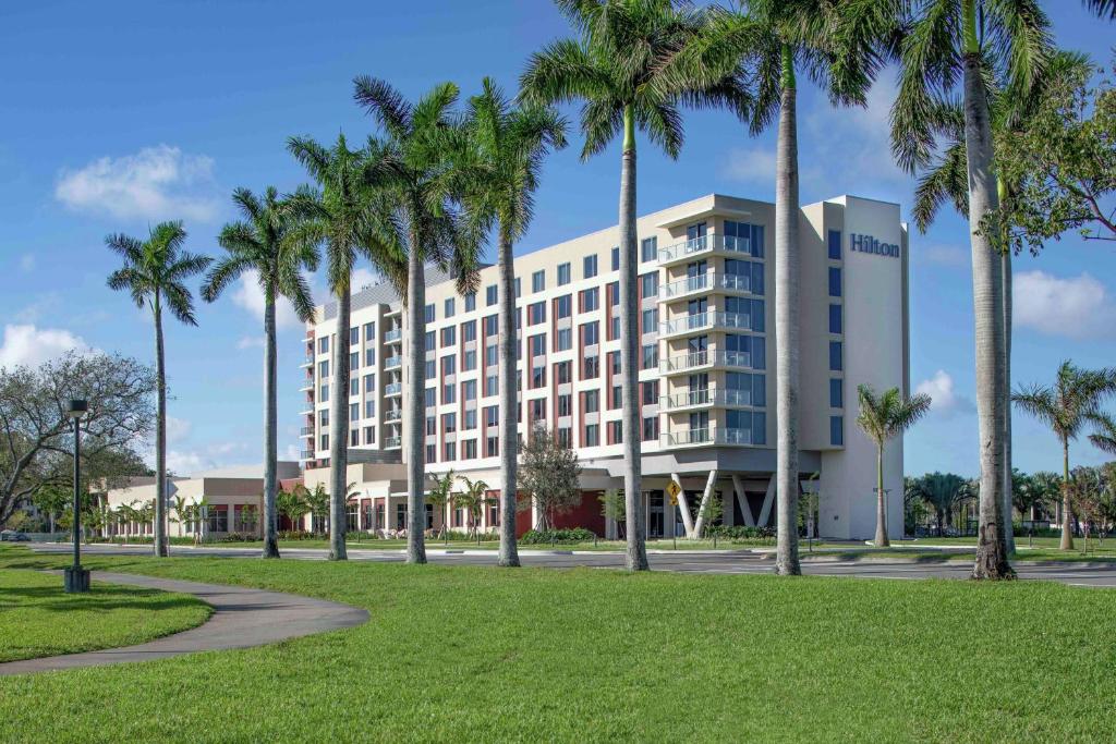 南迈阿密Hilton Miami Dadeland的公园前有棕榈树的建筑