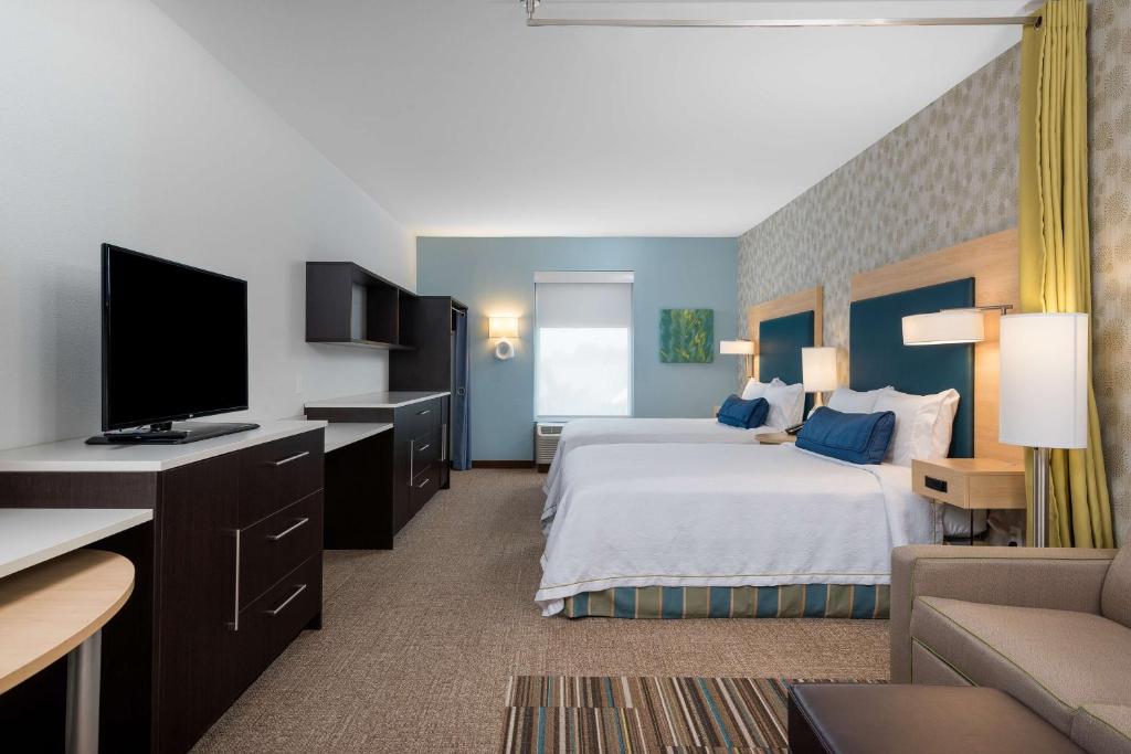 夏洛特夏洛特大学研究园希尔顿欣庭2号套房酒店的配有一张床和一台平面电视的酒店客房