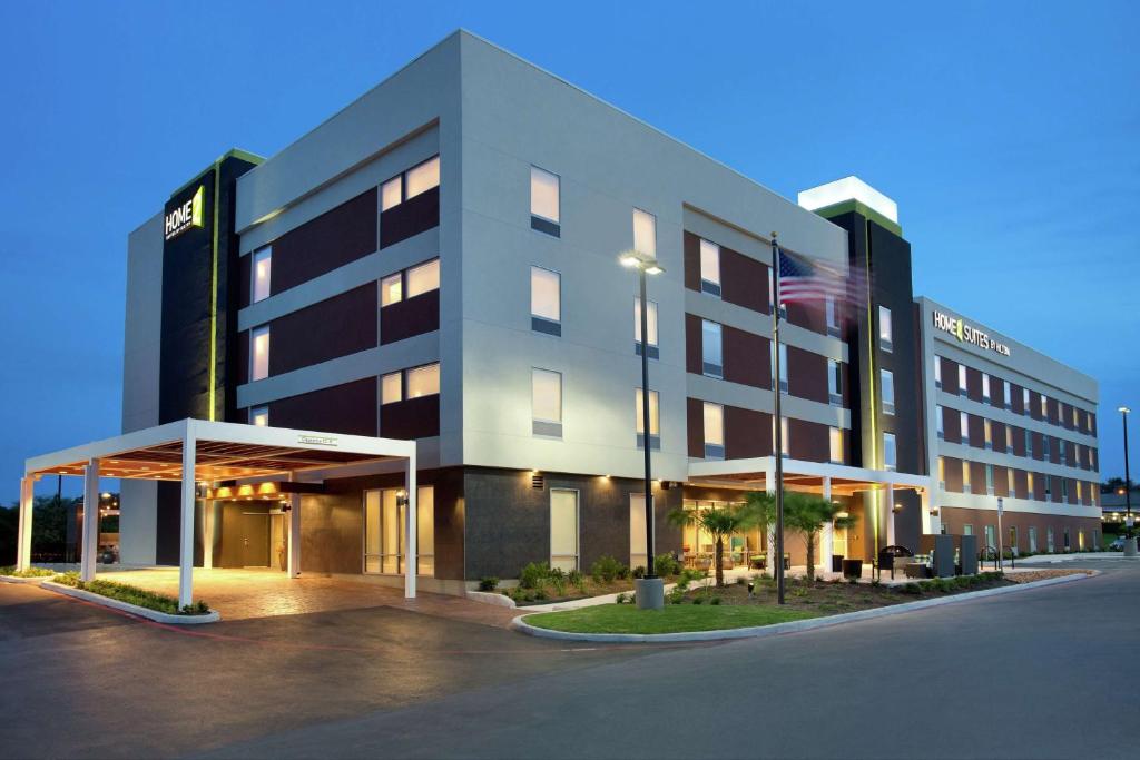 圣安东尼奥德州圣安东尼奥机场希尔顿欣庭套房酒店的前面有美国国旗的建筑