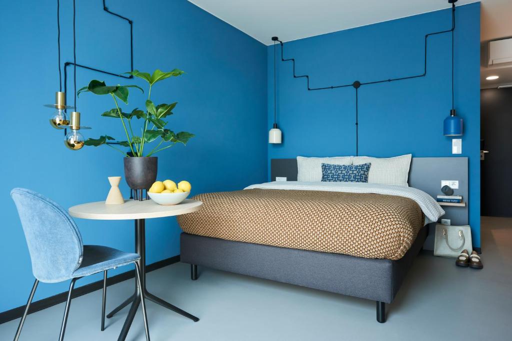 波鸿Nena Apartments Bochum City的蓝色卧室配有床、桌子和椅子
