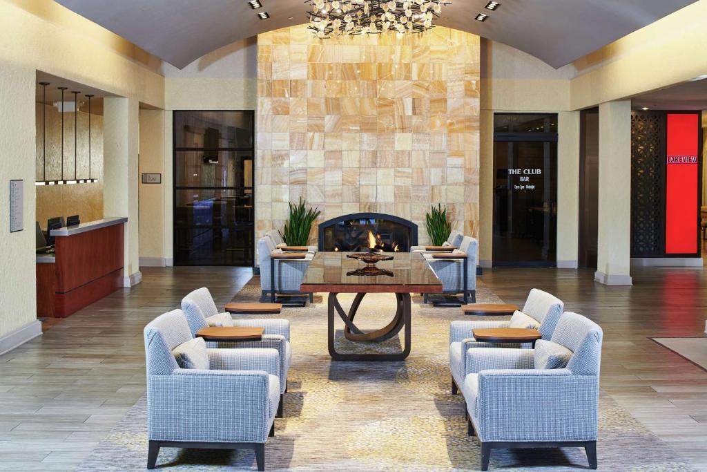 盐湖城盐湖城机场希尔顿逸林酒店的大堂设有桌椅和壁炉。