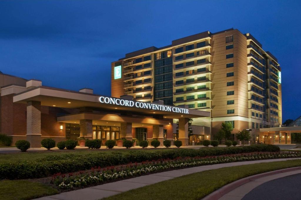 康科德Embassy Suites by Hilton Charlotte Concord Golf Resort & Spa的夜间会议中心建筑的 ⁇ 染