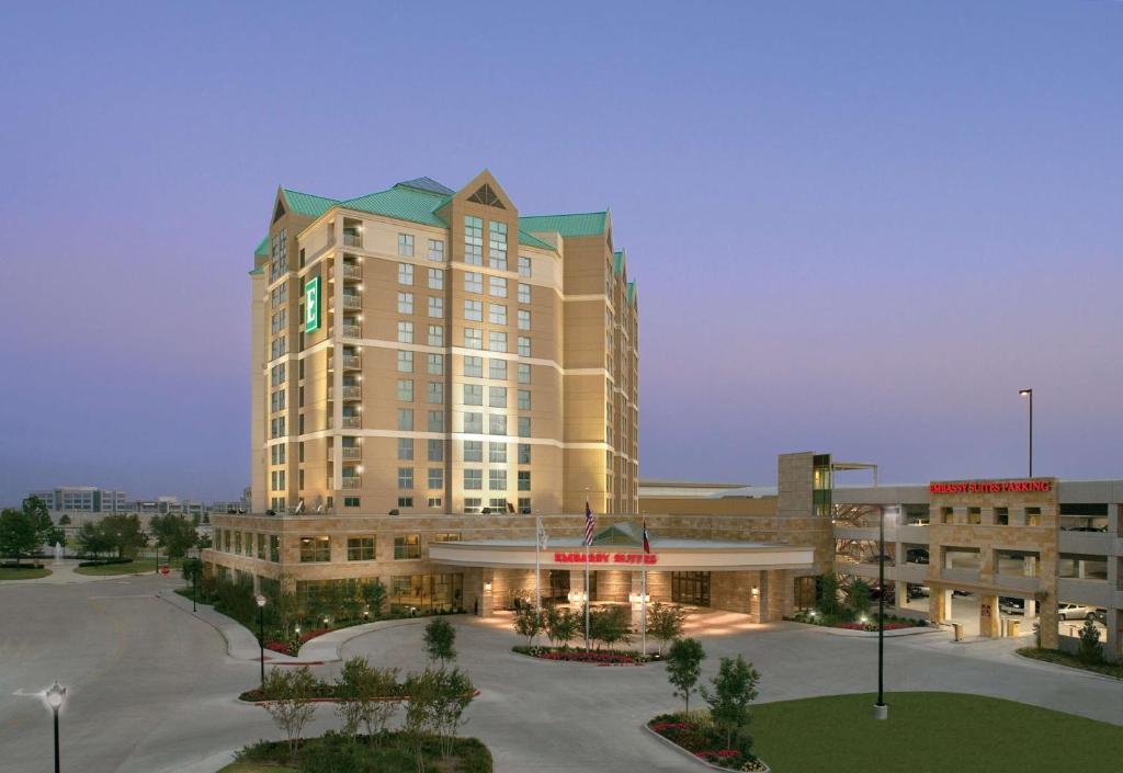 弗赖拉辛Embassy Suites by Hilton Dallas Frisco Hotel & Convention Center的一座大型建筑,前面设有停车场