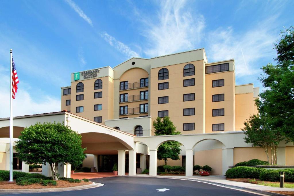 格林斯伯勒Embassy Suites by Hilton Greensboro Airport的前面有美国国旗的酒店