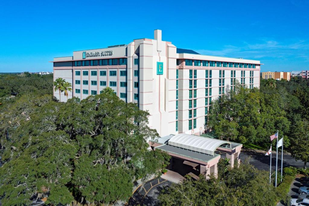 坦帕Embassy Suites by Hilton Tampa USF Near Busch Gardens的一座白色的大建筑,上面有绿色的标志
