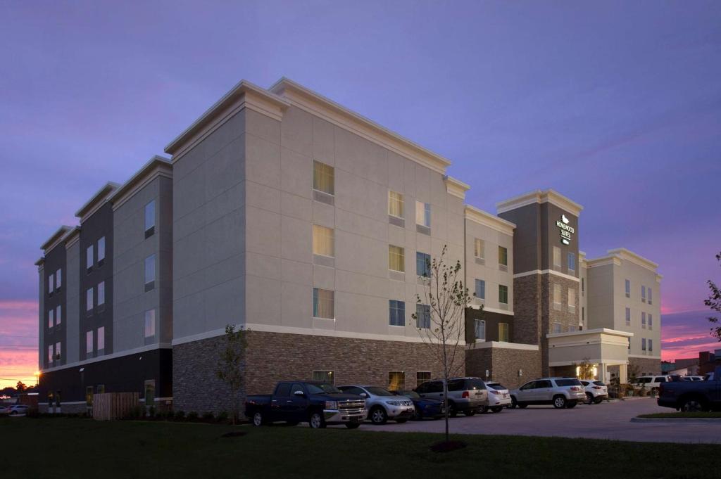 梅泰里Homewood Suites by Hilton Metairie New Orleans的停车场内停放汽车的大型建筑