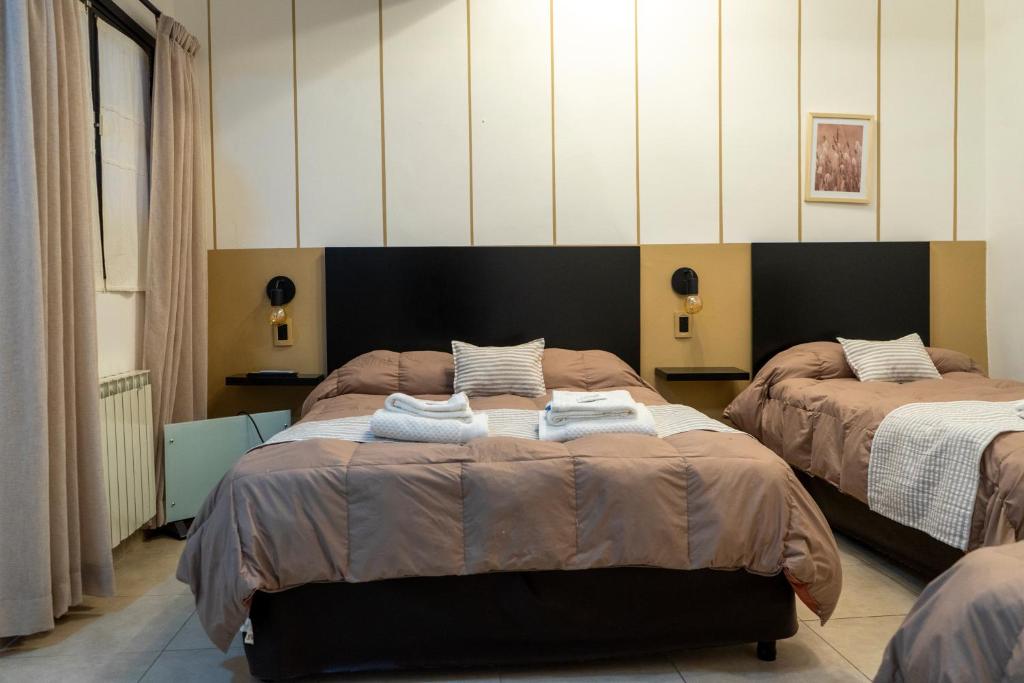 萨尔塔Hotel del Tren的一间卧室配有两张带毛巾的床