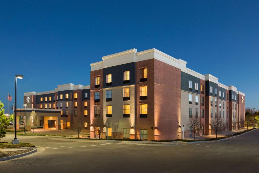 恩格尔伍德丹佛科技中心希尔顿惠庭套房酒店的停车场里一座带灯的大型砖砌建筑