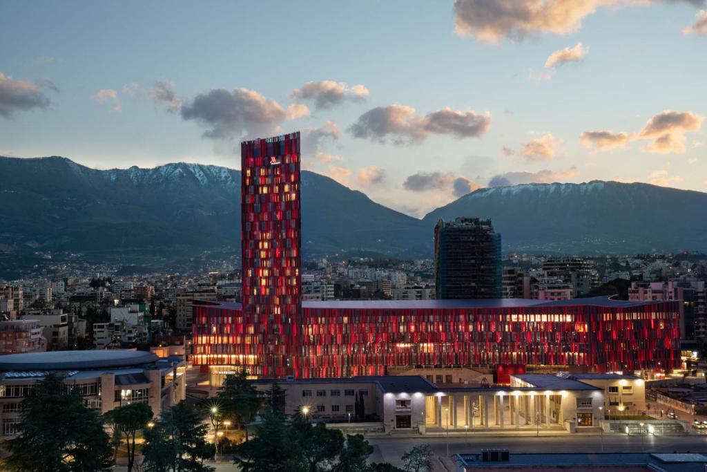 地拉那Tirana Marriott Hotel的城市前方有红灯的高楼