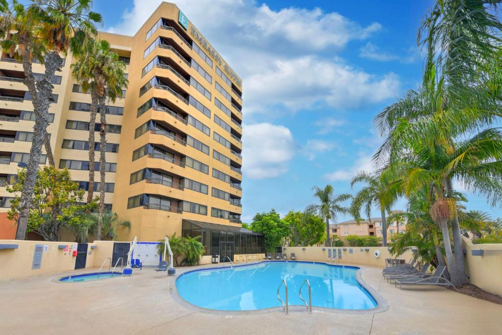 安纳海姆奥兰治阿纳海姆希尔顿合博套房酒店的棕榈树建筑前的游泳池