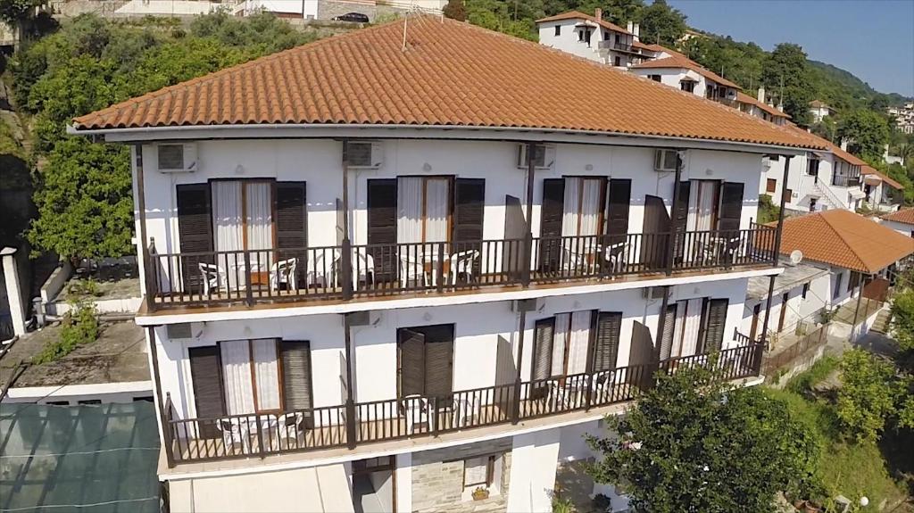 阿吉奥斯伊欧尼斯塞维利酒店的带阳台和棕色屋顶的白色建筑