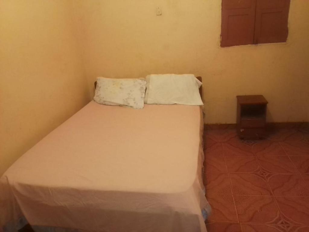 罗安达Hospedaria Zac的一间小卧室,房间内设有一张白色的床