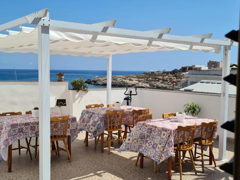 兰佩杜萨Casa Nautilus - 30m dal mare的一个带桌椅的庭院和大海