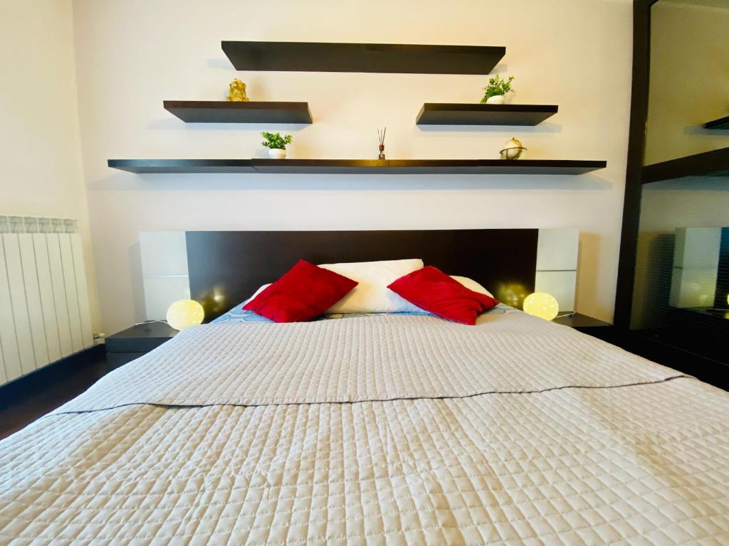 蒙法尔科内Red House的卧室配有白色床和2个红色枕头
