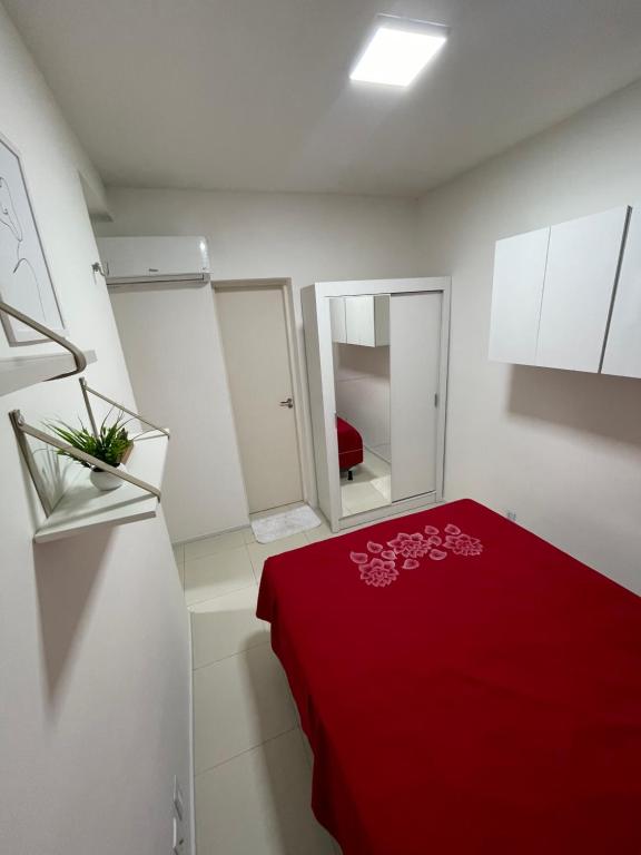 北茹阿泽鲁Apartamento em condomínio 24 hrs的一间设有红色床和红色毯子的房间