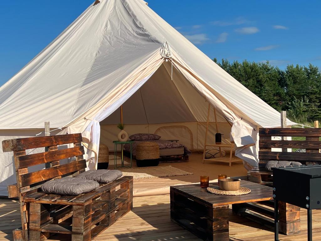 鲁斯内Glamping Rusne的帆布帐篷,配有两把椅子和一张桌子