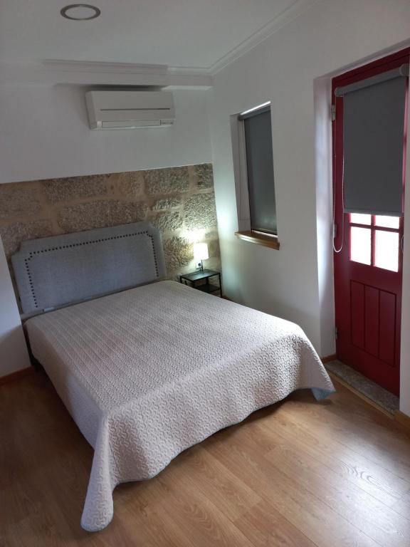 瓜尔达TORREÃO HOUSE的一间卧室设有一张床和一扇红色的门