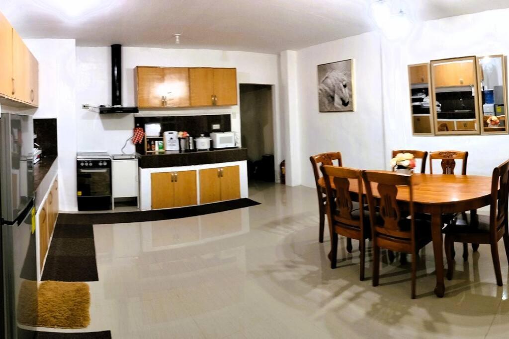 达沃市Stellar Homesharing (Home #2)的厨房以及带桌椅的用餐室。