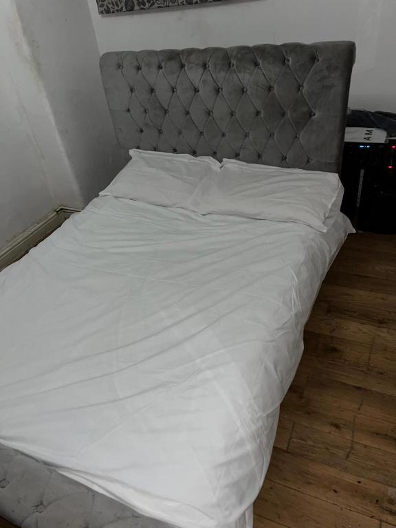 伦敦Home 2 Home的白色的床,配有灰色床头板和白色床单