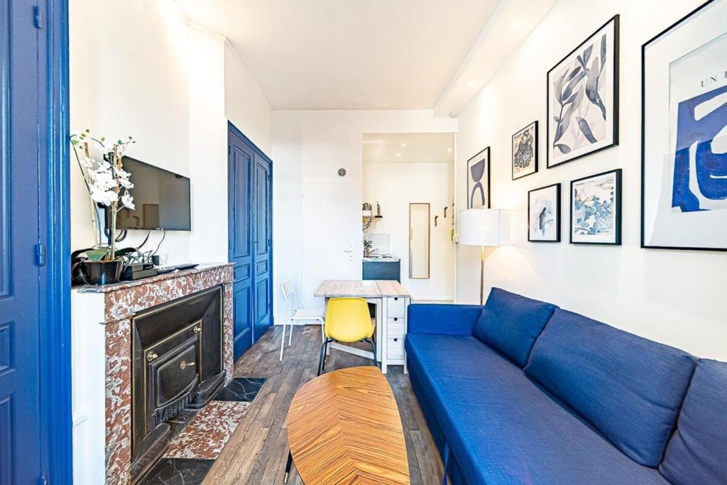 里昂Le petit Charlemagne- Studio Rénové -Perrache的客厅设有蓝色的沙发和壁炉