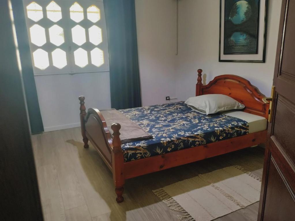 库鲁Villa Gardenia的一间卧室配有一张木框床和窗户。