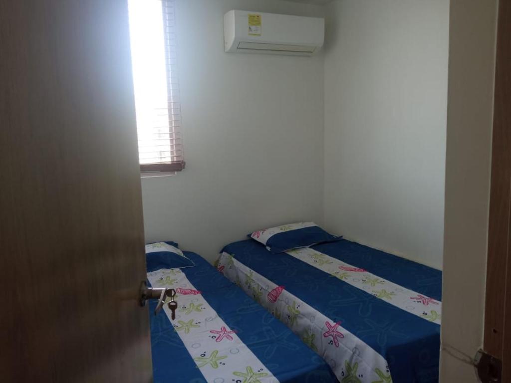 科韦尼亚斯Cómodo apartamento cerca al mar的一间卧室设有两张床和窗户。