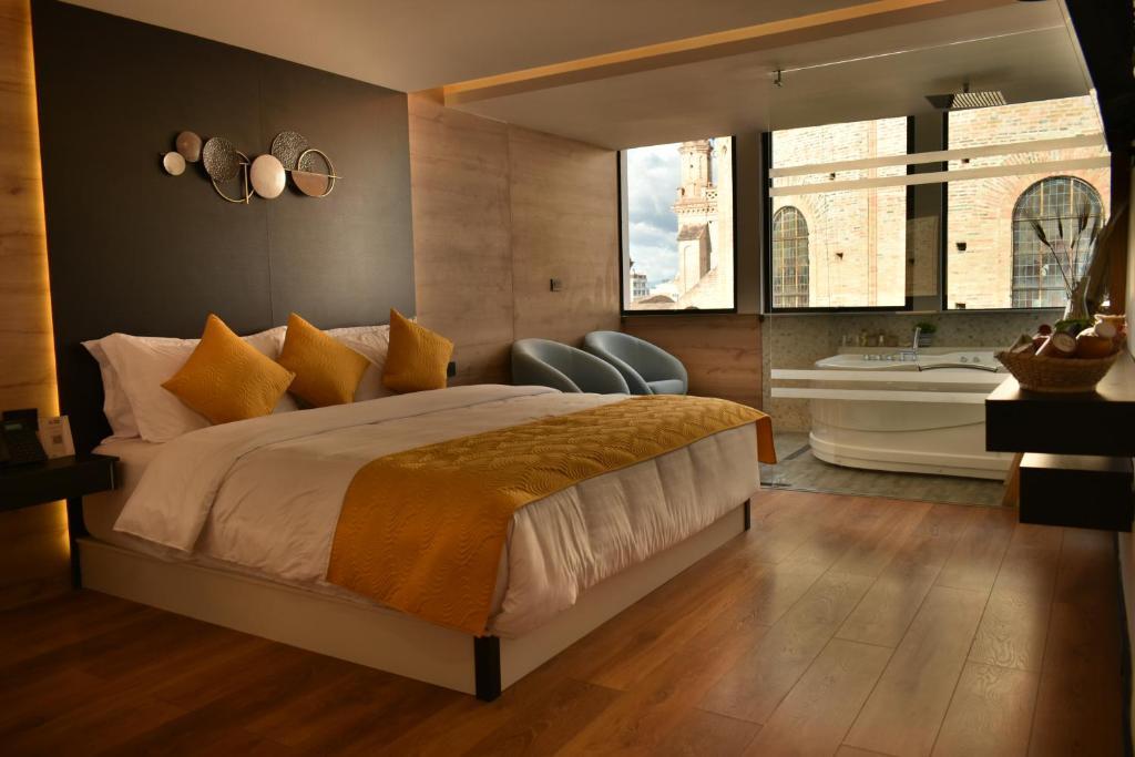 昆卡Hotel Vaway的一间卧室配有一张大床、一个浴缸和窗户。
