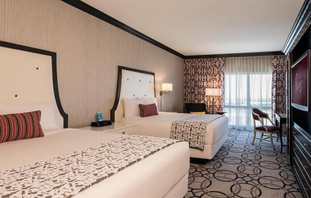 拉斯维加斯Attractive Unit by Paris Casino Heart of Strip Las Vegas的酒店客房设有两张床和电视。