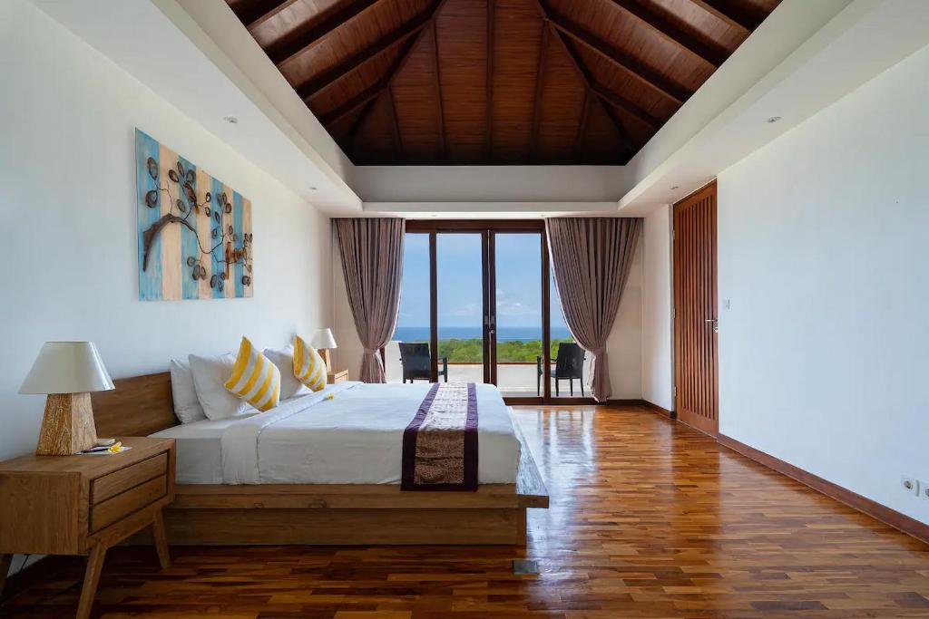 乌鲁瓦图Vivo Villas - Villa Vivo的一间卧室设有一张床和一个大窗户