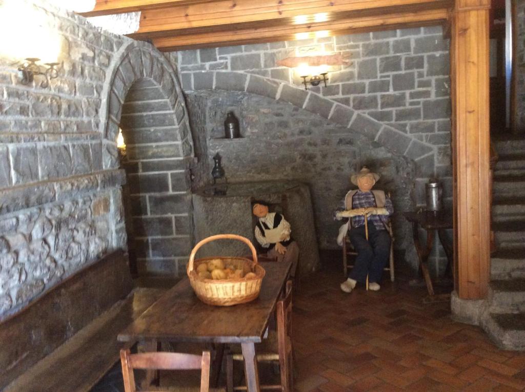 拉武埃尔达方达卡雷拉宾馆的一间设有砖炉的房间,里面装有两个娃娃