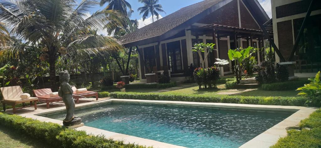 Petang** 5BR for 10+ guest, amazing place relaxing ubud ***的房屋前设有雕像的游泳池