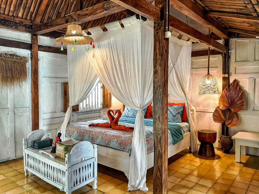婆罗浮屠嘉怒尔别墅旅馆的一间卧室配有带窗帘的天蓬床