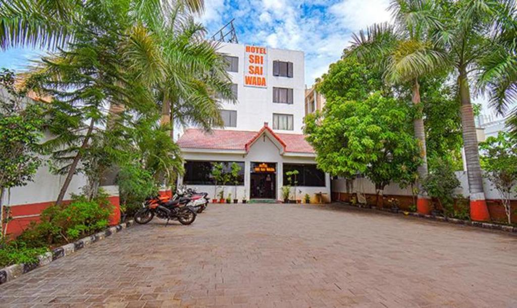 舍地Hotel Shree Sai Wada Shirdi的停在前面的一座带摩托车的建筑