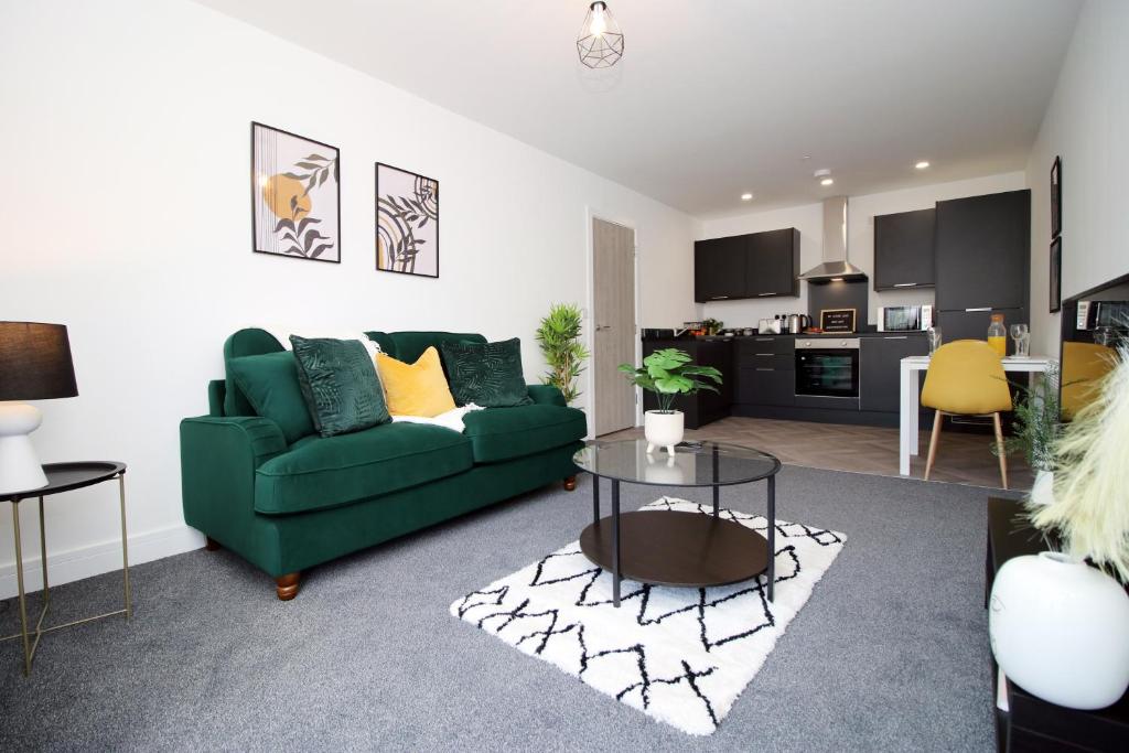 卡迪夫New Modern 1 Bedroom Apartments - Prime Location - By EKLIVING LUXE Short Lets & Serviced Accommodation - Cardiff的客厅配有绿色沙发和桌子