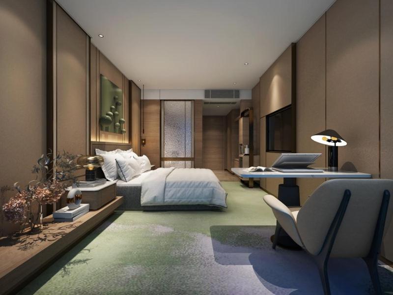 蚌埠格丽蚌埠万达广场南翔城市广场酒店的一间卧室配有一张床、一张桌子和一把椅子