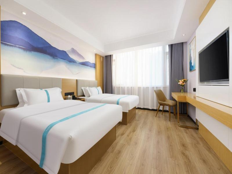 大连格菲辽宁省大连市甘井子区周水子机场酒店的酒店客房设有两张床和一台平面电视。