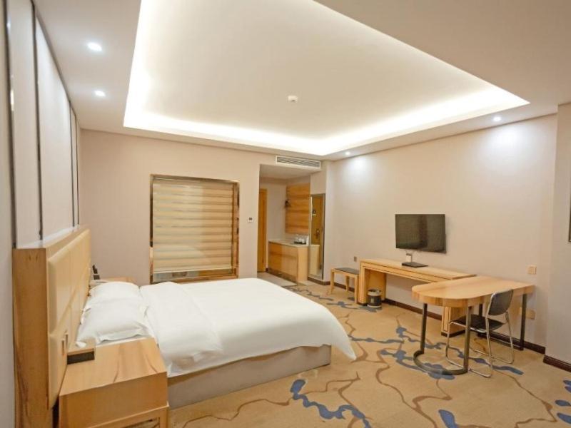 宜春格菲宜春市袁州区政府高铁站酒店的一间卧室配有一张床、一张书桌和一台电视