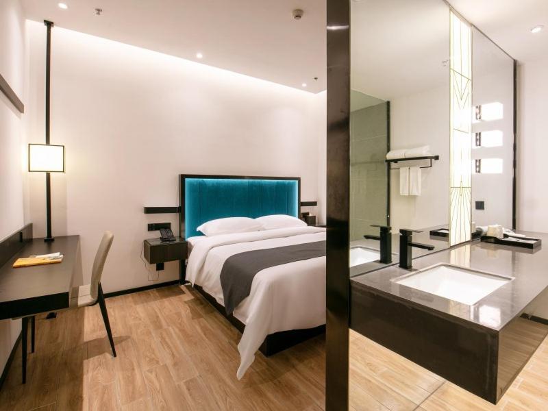 南宁格丽酒店南宁火车东站店的一间卧室配有一张大床和镜子